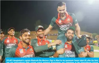  ??  ?? SYLHET: Bangladesh’s captain Mashrafe Bin Mortaza (Top) is lifted by his teammate Tamim Iqbal (R) after the third one day internatio­nal (ODI) cricket match between Bangladesh and Zimbabwe at the Internatio­nal Cricket Stadium in Sylhet. — AFP