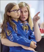  ?? VASHA HUNT — THE ASSOCIATED PRESS ?? Meredith Dixon points out interestin­g visuals to her daughter Birdie, a space camp participan­t, as they listen to a talk on space flight from NASA astronaut Dottie Metcalf, at the U.S. Space &amp; Rocket Center in Huntsville, Ala., on July 13. Huntsville’s tourism industry is rooted in the U.S. space program and its critical, ongoing research into getting astronauts back to the moon and on to Mars.