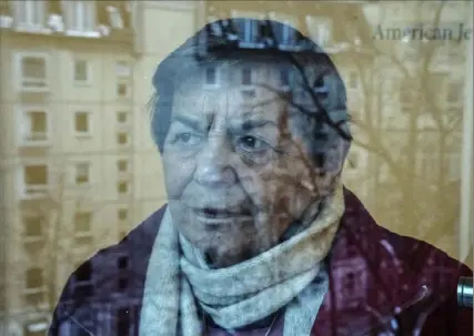  ?? Ebrahim Noroozi/Associated Press ?? Ruth Winkelmann, 95, a survivor of the Holocaust, is reflected in a window at her home in Berlin earlier this month. Almost 80 years after the Holocaust ended, about 245,000 Jewish survivors live in more than 90 countries. A new report reveals that nearly half of them, or 49%, are in Israel, 18% in Western Europe, 16% in the United States, and 12% in countries of the former Soviet Union.