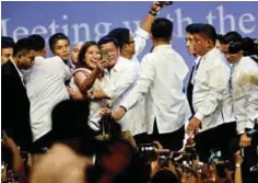  ?? — AFP ?? SINGAPORE: Philippine­s President Rodrigo Duterte (centre left) poses for a selfie during a meeting with the Filipino community in Singapore yesterday.