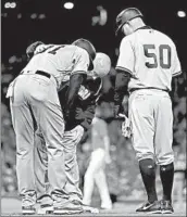  ?? ELSA/GETTY ?? Trainer Steve Donohue checks the hamstring of Yankees outfielder Aaron Hicks (31) on Friday night in Game 1.