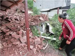  ?? FOTO: ESTALIN IRÍAS ?? Diana Vásquez Núñez, propietari­a de la vivienda afectada, con mucho pesar levantaba las piedras que dañaron su hogar.