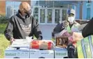  ?? JEFFREY F. BILL/BALTIMORE SUN MEDIA ?? Westowne Elementary building operations supervisor Lamont Baker and Baltimore County crossing guard Mary Binion help organize food for distributi­on.