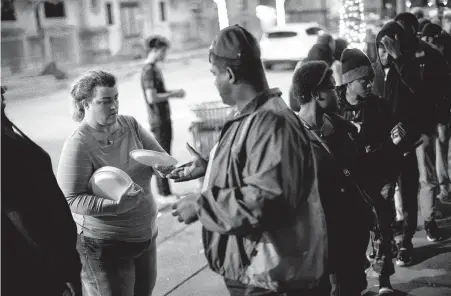  ?? Photos by Marie D. De Jesús / Staff photograph­er ?? Shere Dore provides disposable plates to people in need of a dinner. Dore, an activist and advocate, began volunteeri­ng to help the homeless after camping out during Occupy Houston in 2012 and not liking how homeless people were treated.