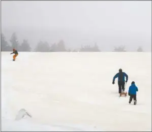  ?? (AP/Matthias Schrader) ?? People enjoy the day as Sahara sand colors the snow near Altenberg, Germany, on Sunday.