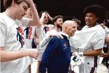  ?? D. Ross Cameron/Associated Press ?? St. Mary’s head coach Randy Bennett is congratula­ted by his players after notching his 500th career coaching victory.