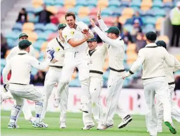  ?? AP ?? James’ joys Australia’s James Pattinson (centre), celebrates with teammates after dismissing West Indies’ Jermaine Blackwood during the first Test in Hobart, yesterday.