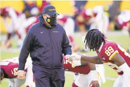  ?? MARK TENALLY/ AP ?? Washington coach Ron Rivera greets wide receiver Cam Sims ( 89) before a game against the Panthers on Dec. 27 in Landover.