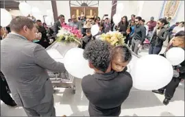 ?? Al Seib Los Angeles Times ?? MOURNERS surround the caskets of a couple killed last month when their car overturned while f leeing ICE agents. Police called for a review of the incident.