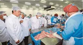  ?? PIC BY HAZREEN MOHAMAD ?? Deputy Prime Minister Datuk Seri Dr Ahmad Zahid Hamidi (fourth from left) and Negri Sembilan Menteri Besar Datuk Seri Mohamad Hasan visiting the HyFresh chicken processing facility in Rembau yesterday.