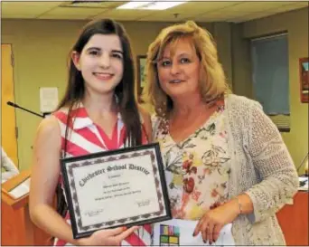  ?? LORETTA RODGERS – DIGITAL FIRST MEDIA ?? Chichester School Board President Ruth Ann Baiocco, rights, presents Chichester High School senior Melanie Dempsey with a framed certificat­e recognizin­g her for having an essay published in the Johns Hopkins publicatio­n, Imagine.