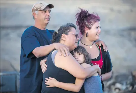  ?? DARRYL DYCK/THE CANADIAN PRESS ?? Randy Thorne, left, his wife Angie Thorne, second left, their daughter Kelsey Thorne and granddaugh­ter Nevaeh Porter, 8, are overcome with emotion on Sunday upon viewing the remains of their home on the Ashcroft First Nation that was destroyed by...