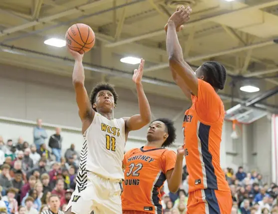  ?? KIRSTEN STICKNEY/SUN-TIMES ?? Joliet West’s Jeremy Fears Jr., who had 28 points, including 11 in the fourth quarter, shoots over Young’s Marcus Pigram (32) and Daniel Johnson.