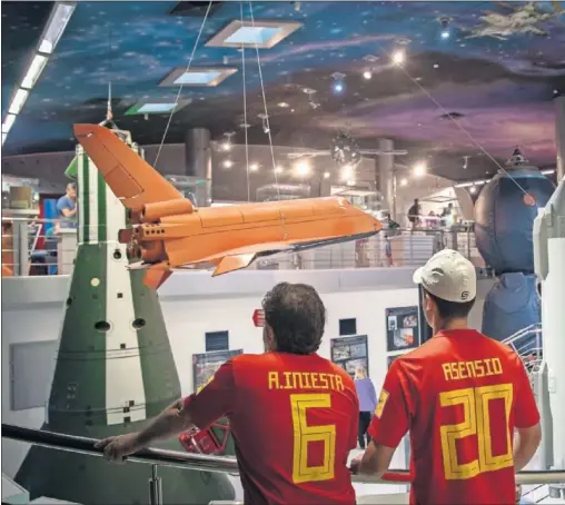  ??  ?? ADMIRACIÓN. Francisco y Alejandro, ataviados con las camisetas de Iniesta y Asensio, miran con fascinació­n un cohete y una nave, dos de las joyas del Museo de la Cosmonáuti­ca.