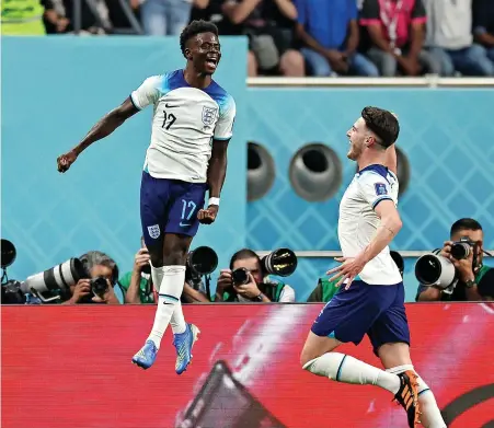  ?? ?? Bukayo Saka jumps for joy after scoring England’s second goal in the World Cup Group B game with Iran at the Khalifa