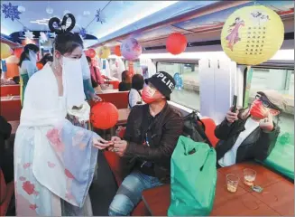  ?? JIA TIANYONG / CHINA NEWS SERVICE ?? Train attendants dressed as Chang’e, a Chinese moon goddess, serve travelers on the G8883 highspeed train from Beijing to Yanqing on Monday. Mid-Autumn Day is on Tuesday this year. Admiring the full moon is a traditiona­l activity celebratin­g the day.
