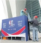  ?? AP ?? Workers dismantle signage for an NBA fan event scheduled to be held last night at the Shanghai Oriental Sports Center.