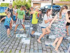  ?? FOTO: EVA WINKHART ?? Auch dazu ist die Schwäbisch­e Zeitung von Nutzen: Die Kinder retten sich auf die Zeitungsin­seln.
