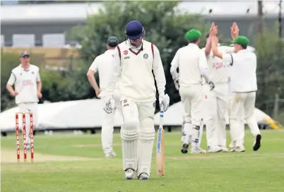  ??  ?? ● Mochdre’s Adam Buckley walks back as Pwllheli players celebrate his dismissal. Pic: David Powell