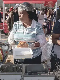  ??  ?? A street vendor prepares a ‘Kota’ sandwich during the Kota Festival.