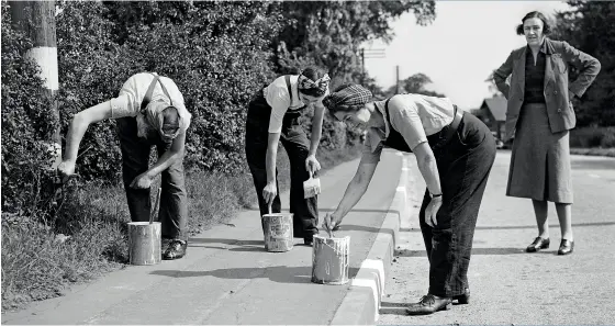  ??  ?? BELOW Women doing men’s jobs, painting the kerb white so it can be seen during the blackout. 1941