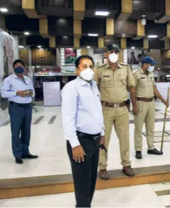 ??  ?? CORPORATIO­N OFFICIALS and policemen stand guard outside the Surat Textile Market, which was sealed following a spike in COVID-19 cases, on July 6.