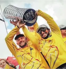  ?? Gulf News Archives ?? Head over heels Abu Dhabi Ocean Racing skipper Ian Walker (left) and Emirati helmsman Adel Khalid hold the Volvo Ocean Race Trophy.