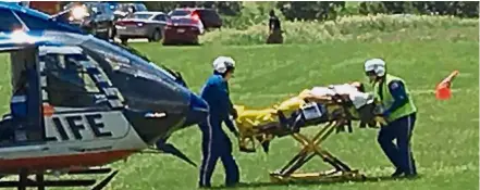  ??  ?? Emergency: Medical personnel transporti­ng the injured pilot of a blimp that crashed in a field near Erin Hills on Thursday. — Reuters