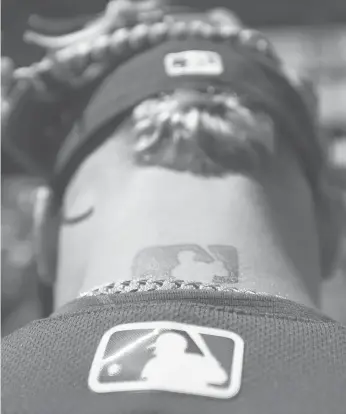 ?? DARRON CUMMINGS/AP ?? In this 2017 photo, the major league baseball logo is shown tattooed on MLB shortstop Javier Baez.