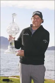  ?? Eric Risberg / Associated Press ?? Phil Mickelson poses with his trophy after winning the AT&amp;T Pebble Beach Pro-Am on Monday.