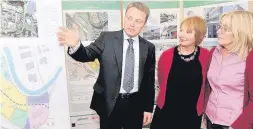  ??  ?? Vision of the future Keith Vallance from Forrest Developmen­ts shows two residents the plans for the Hoover site in Cambuslang in 2011