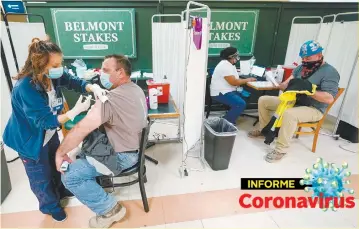  ??  ?? Una enfermera aplica la primera dosis de la vacuna de Pfizer contra el coronaviru­s a trabajador­es de la industria metalúrgic­a en Belmont Park, en Nueva York