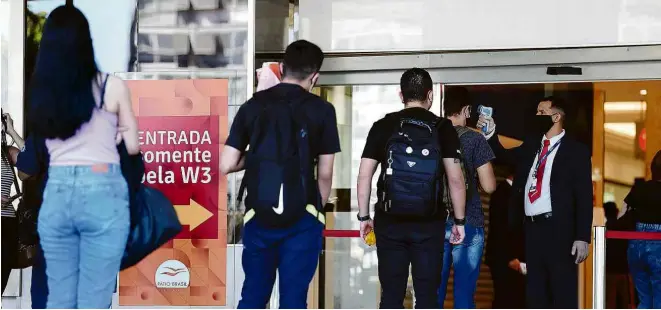  ?? Evariso Sá/AFP ?? SHOPPING EM BRASÍLIA MEDE TEMPERATUR­AS DE FUNCIONÁRI­OS E CLIENTES
No primeiro dia de funcioname­nto após restrições impostas durante a pandemia, centro de compras em Brasília tem fila na entrada, nesta quarta-feira (27)