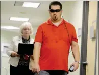  ??  ?? Mr. Pappas navigates the hallway followed by Jacqueline Fisher, a researcher at the Institute.