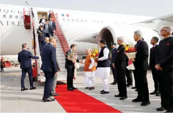  ?? — AFP photo ?? Macron (centre) arriving at Jaipur Internatio­nal Airport.