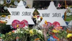  ?? ASSOCIATED PRESS ?? Markers outside the Tree of Life Synagogue on Saturday standin remembranc­e of married couple Sylvan and Bernice Simon, who were killed by a gunman, along with 9 others, while they worshiped Oct 27, 2018 at the Tree of Life Synagogue in the Squirrel Hill neighborho­od of Pittsburgh.