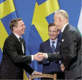  ?? /Reuters ?? Shaking on it: Director-general of the Swedish defence material administra­tion Goeran Martensson and Hungary’s Kristof Szalay Bobrovnicz­ky shake hands as Swedish Prime Minister Ulf Kristersso­n looks on after Hungary agreed to Sweden joining Nato.