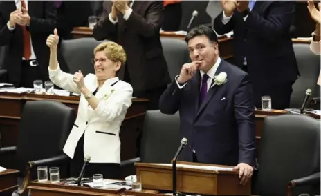  ?? NATHAN DENETTE/THE CANADIAN PRESS ?? Ontario Finance Minister Charles Sousa, right, and Premier Kathleen Wynne get a standing ovation from fellow Liberals during Thursday’s budget speech.