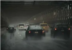  ?? ANDRES KUDACKI — THE ASSOCIATED PRESS ?? Cars move along Brooklyn Bridge under heavy rain on Friday, Sept. 29, 2023 in Brooklyn borough of New York. A potent rush-hour rainstorm swamped the New York metropolit­an area on Friday, shutting down parts of the city’s subway system, flooding streets and highways, and delaying flights into Laguardia Airport.