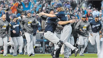  ?? JOHN LEYBA THE ASSOCIATED PRESS ?? Milwaukee reliever Josh Hader, front right, jumps on catcher Erik Kratz after getting Colorado Rockies’ Ian Desmond for the final out in a 6-0 win Sunday in Denver. The Brewers advance to the National League Championsh­ip Series against the Los Angeles Dodgers, who won, 6-2, on Monday over the Braves in Atlanta to take that division series in four games. For a Dodgers story, see therecord.com.