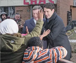  ?? CP PHOTO ?? Prime Minister Justin Trudeau (right) and Toronto Mayor John Tory greet residents after visiting a housing developmen­t in Toronto’s Lawrence Heights neighbourh­ood to make a policy announceme­nt on Wednesday.