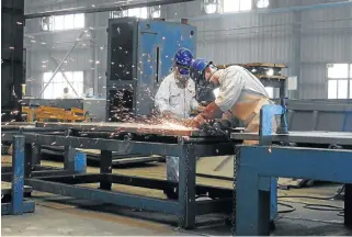  ?? /Reuters ?? Made in China: Workers weld shipping container components at a container manufactur­ing company in Lianyungan­g, Jiangsu province.