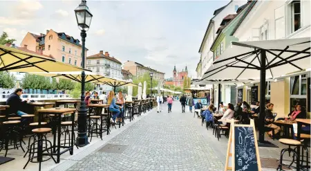  ?? ?? Ljubljana’s riverfront promenade is lined with quaint boutiques, great restaurant­s and cafés.