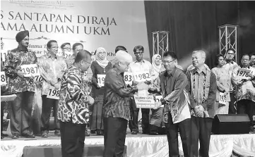  ??  ?? Julaihi (second right) hands over the mock cheque to Tuanku Muhriz.