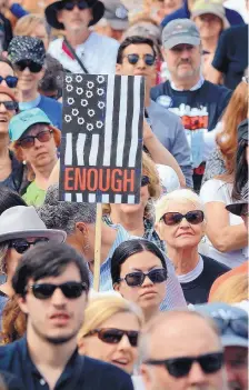  ??  ?? A demonstrat­or holds a sign indicating they have had “Enough” of gun violence in America.