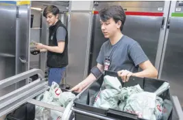  ?? RYAN TAPLIN/SALTWIRE NETWORK ?? Atlantic Superstore employees Alexander # (left) and Luke Selig pack online orders at the Joseph Howe Dr. store in Halifax on Monday.