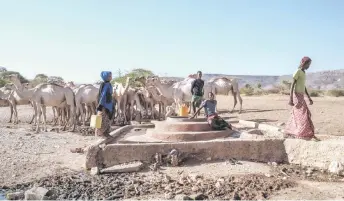  ?? — AFP photos ?? People stand next to a water well at the village of El Gel, 8 kilometres from the town of K’elafo, Ethiopia.