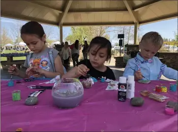  ?? KYRA GOTTESMAN — MERCURY-REGISTER ?? Left to right, twins Hope and Faith Griffiths, 6, and Micah Struggle, 3, let their creativity flow painting rocks Saturday in the Little Bear Pavilion at the 13th Annual Feather River Recreation and Park District’s Wildflower and Nature Festival in Oroville. The rock painting activity for kids was sponsored by Oroville Rocks.