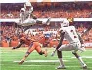  ?? RICH BARNES, USA TODAY SPORTS ?? Lamar Jackson, hurdling a Syracuse defender, has displayed his athleticis­m in a Louisville offense tailored to his skill set.