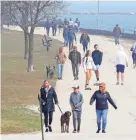  ?? MIKE DE SISTI / MILWAUKEE JOURNAL SENTINEL ?? Crowds of people get out for fresh air and exercise Wednesday near Veterans Park along Lake Michigan in Milwaukee.